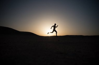gün batımı, genç beyaz koşmak dağ içinde siluet koşan adam