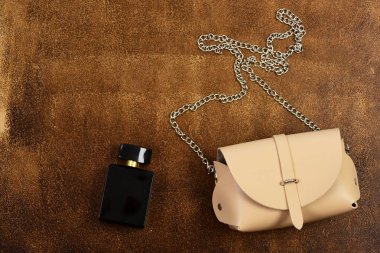 Zincir ve parfüm şişesi ile bej çanta