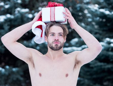 Kışın açık havada hediye kutusuyla yakışıklı kaslı adam.