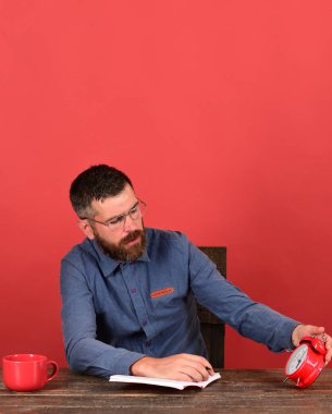 Adam sakal ve gözlük tutan çalar saat ve defter