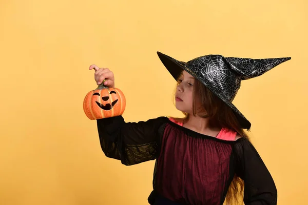 Halloween en kostuumfeest concept. Meisje met gesneden oranje pompoen — Stockfoto