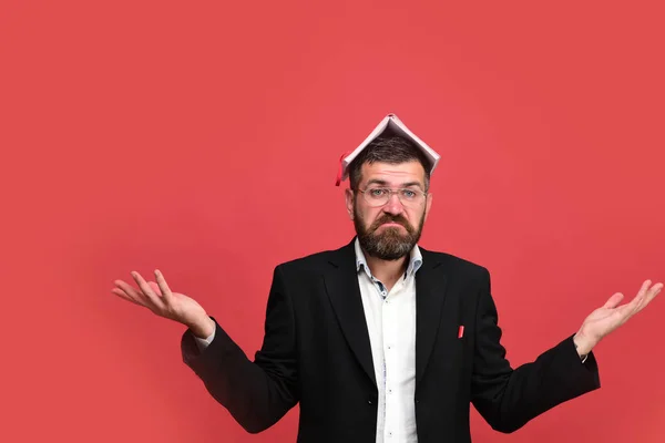 Mann im klassischen Outfit mit Bart hält Buch auf dem Kopf — Stockfoto