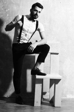 Stüdyo duvarında ciddi bir yüzü olan sakallı bir adam.