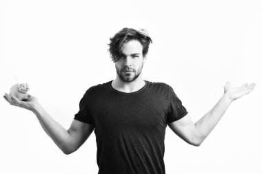 Beyaz seksi genç maço elinde pembe domuz kumbarası tutuyor.