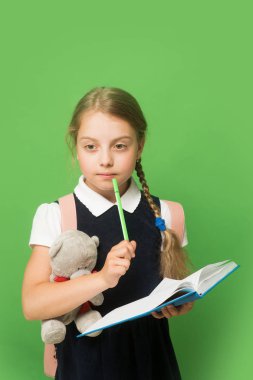 Okul üniformalı çocuk. Öğrenci kitap ve oyuncak ayı tutar