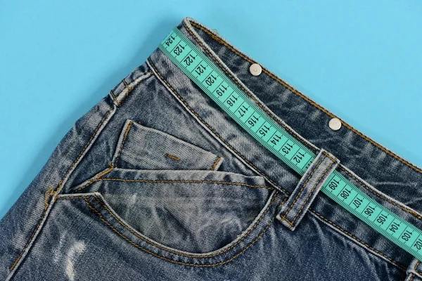 Верхняя часть джинсовых брюк изолированы на синем фоне — стоковое фото