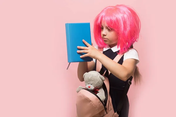 Criança com expressão facial concentrada no fundo rosa claro — Fotografia de Stock