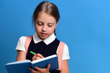 Liseli kız ile mavi arka plan üzerinde çalışkan yüz ifadesi