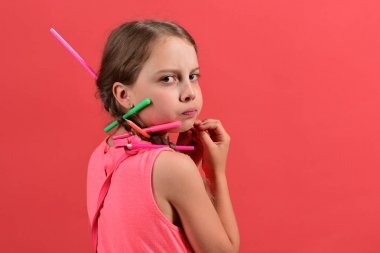 Örgüler, renkli kalemler ve işaretleyiciler ile pembe kıyafeti çocuk