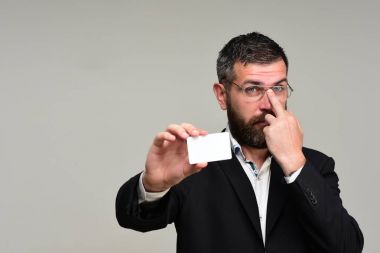 Sakallı takım elbiseli adam beyaz kartvizit tutar