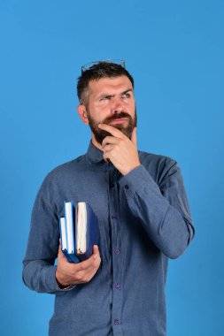 Öğretmen gözlük takar ve Organizatörler tutar. Not defterinde mavi col