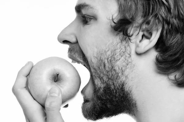 Guy probeert te bijten grote groene appel te kijken — Stockfoto