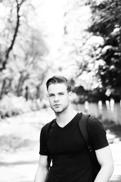 Homme avec coiffure élégante, tenue de sport, sac à dos noir dans le parc — Photo