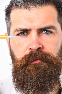 Eye yakınındaki şırınga tutarak şık saç kesimi ile sakallı adam.