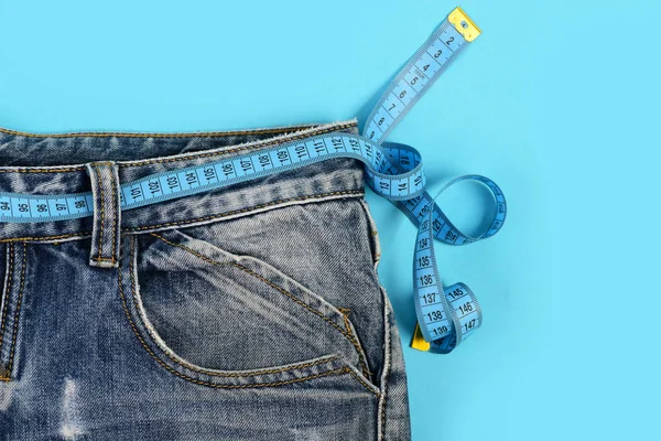 Jeans with measure tape around waist as healthcare concept