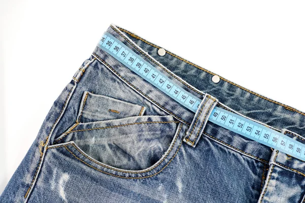 Jeans with measure tape used as belt. Healthy lifestyle concept — Stock Photo, Image
