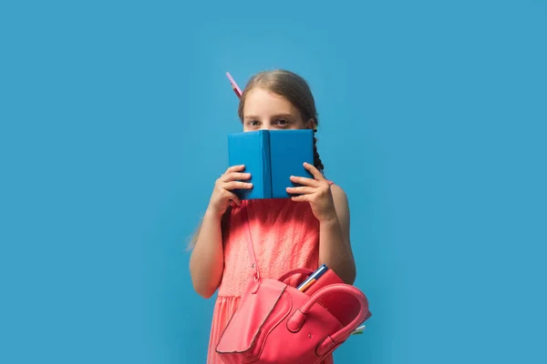 Alumna con trenzas, aislada sobre fondo azul. Regreso a la escuela — Foto de Stock