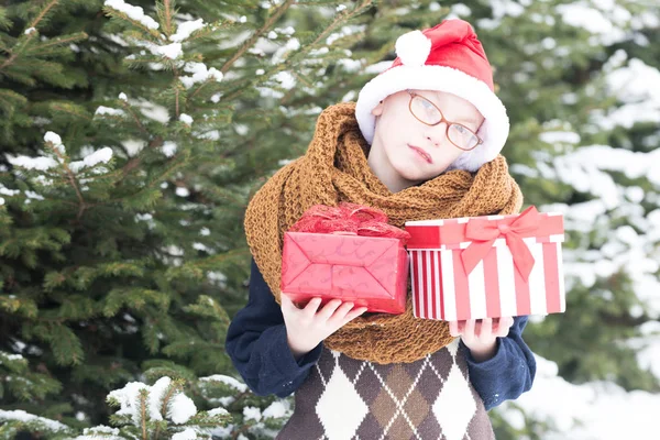 一个小男孩，冬天带着礼物盒在户外 — 图库照片