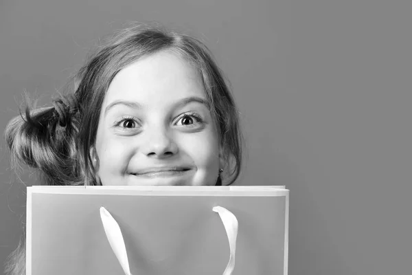 Mädchen mit rosa Einkaufstasche. Kind mit zufriedenem Mienenspiel — Stockfoto