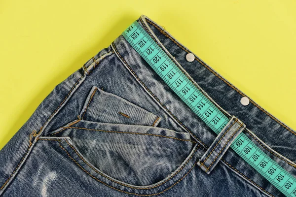 Верхняя часть джинсовых брюк изолирована на желтом фоне . — стоковое фото