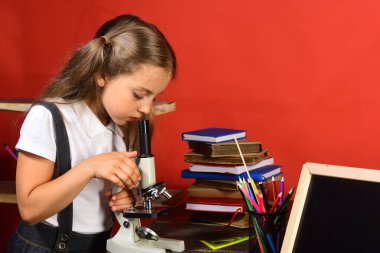 Okul ve laboratuvar malzemeleri kırmızı duvar arka plan üzerinde çocuk