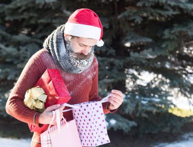 Yakışıklı Noel Baba hediyeleri açar.
