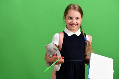 Okul üniformalı, örgülü ve sırt çantalı bir öğrenci.