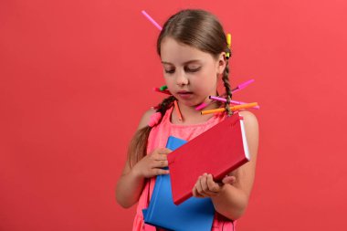 Kızın elinde kırmızı ve mavi kitaplar var. Okula geri dön.