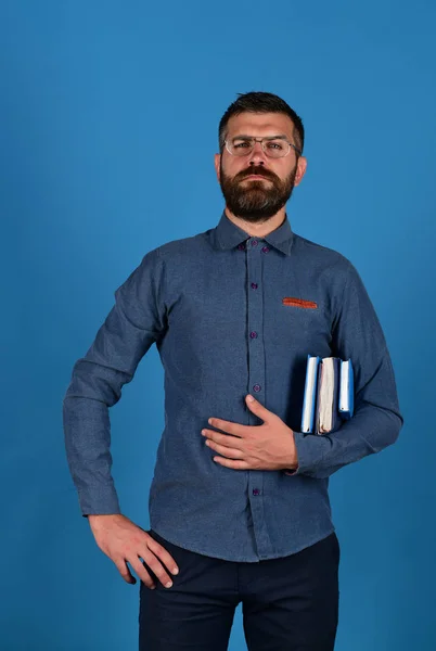 Schoolboeken in blauwe kleur in jongens hand op blauwe achtergrond — Stockfoto