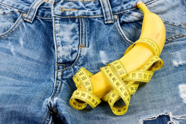 Banaan omwikkeld met geel maatregel tape op jeans, selectieve focu — Stockfoto