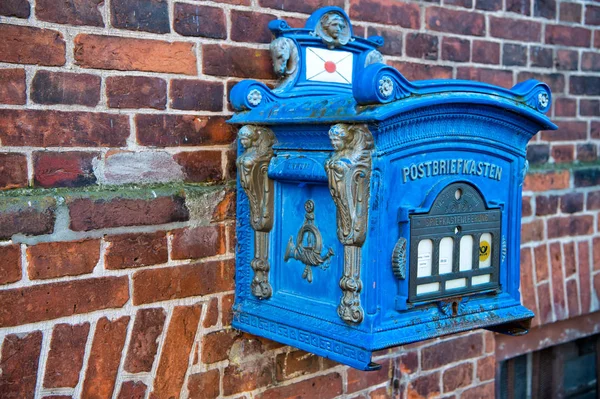 Posta kutusu mavi renk kırmızı tuğla duvar arka plan üzerinde — Stok fotoğraf