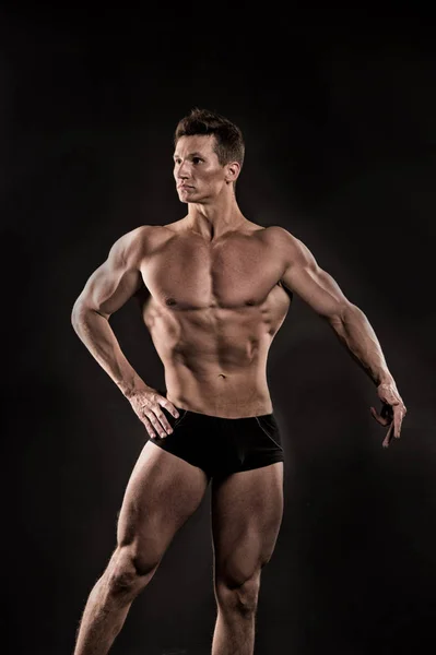 Athletic bodybuilder pose in pants. — Stock Photo, Image