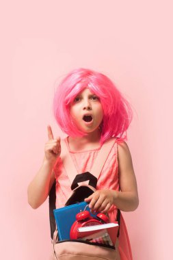 Çalar saati ve kitapları olan bir çocuk. Sırt çantalı kız.