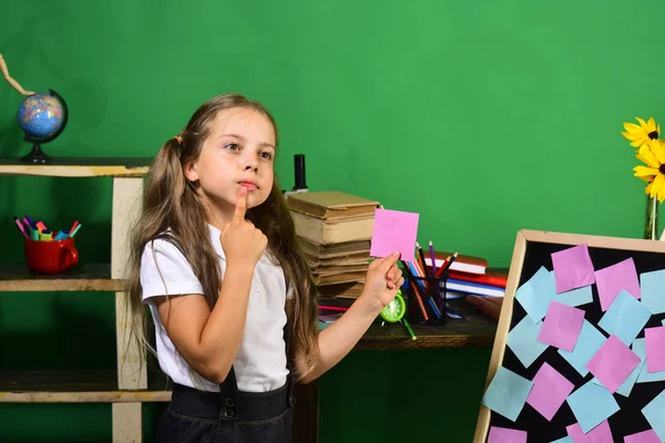 Çocuk ve okul malzemeleri yeşil duvar arka planında — Stok fotoğraf