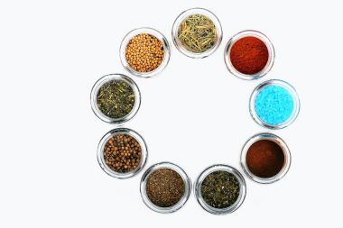 beyaz zemin üzerine kavanoz içinde çeşitli baharatlar