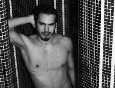 Yakışıklı kaslı seksi adam duşta yıkanıyor.