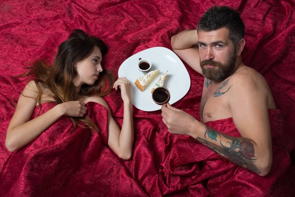 Man with beard having morning coffee with pretty lady.