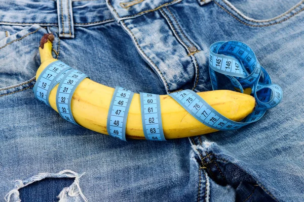 Cremallera Jeans y plátano envueltos con cinta métrica, primer plano . — Foto de Stock