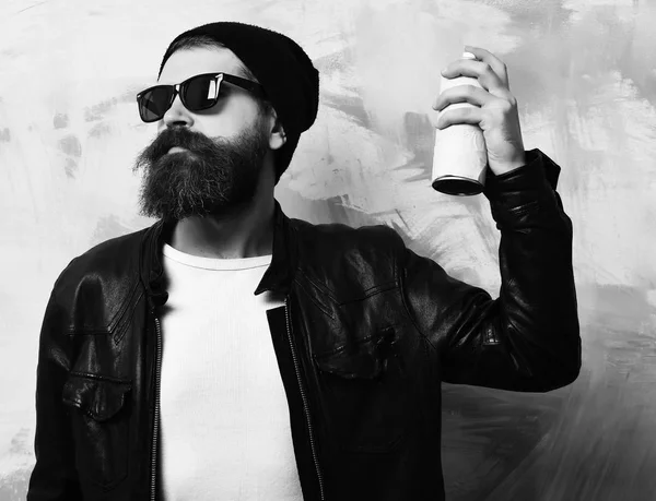 Bearded brutal caucasian hipster holding spray paint — Stock Photo, Image