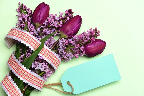 Tulips bunch wrapped with ribbon and turquoise blue tag