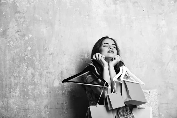 Ziemlich sexy glücklich überraschte Frau mit Einkaufstüten und Kleiderbügeln — Stockfoto