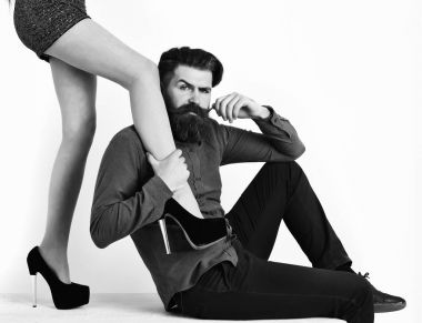 Seksi kadın bacaklı sakallı adam ciddi bir yüze sahip.