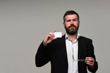 Sakallı takım elbiseli adam beyaz kartvizit tutar