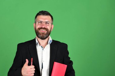 Öğretmen gözlük takar, kalem tutan ve başparmak çıkar ortaya