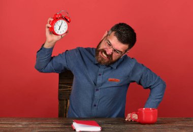 Öfkeli yüzü olan adam ahşap masada oturur