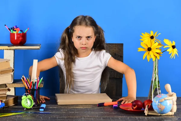 Kızgın surat ifadesi olan kız. Çocuk ve okul malzemeleri — Stok fotoğraf