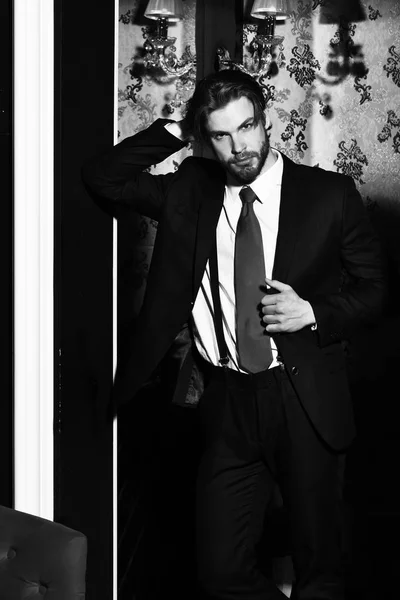 Бородатый человек, бизнесмен в костюме и красный галстук против обоев — стоковое фото