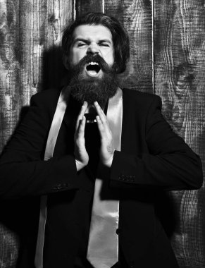 Takım elbiseli beyaz hippi parfüm tutuyor.