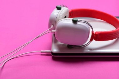 Müzik ve dijital ekipman kavramı. Plastik kulaklık ve gümüş dizüstü