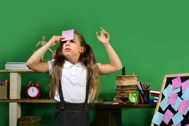 Çocuk ve okul malzemeleri yeşil duvar arka planında